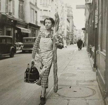 1945年，一位拿着法棍、提着红酒的女士走在巴黎街道-微看VCAN